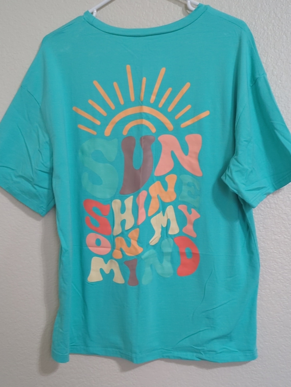 Turquoise Graphic Tee with Colorful Sun Design